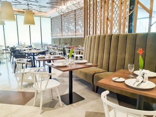 - un restaurant avec des tables et des chaises dans une salle dans l'établissement The Excelsior Hotel Las Piñas, à Manille