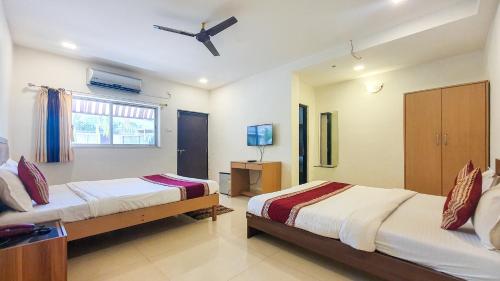 a bedroom with two beds and a tv in it at Rainforest Resort and Spa, Igatpuri -Nature's Luxury Awaits in Igatpuri