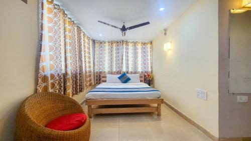 a small bedroom with a bed and a chair at Rainforest Resort and Spa, Igatpuri -Nature's Luxury Awaits in Igatpuri