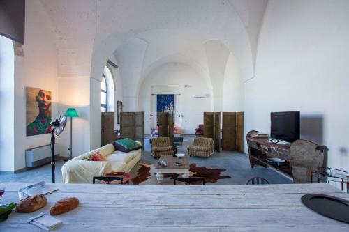 - un salon avec un canapé et une table dans l'établissement Stabilimento Wine & Design Apartment, à Campi Salentina