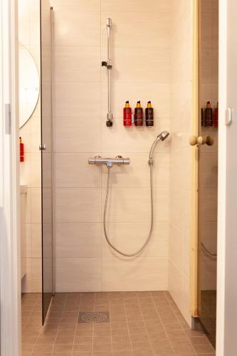 a shower with a glass door in a bathroom at Apartment Lumikontupa in Jyväskylä