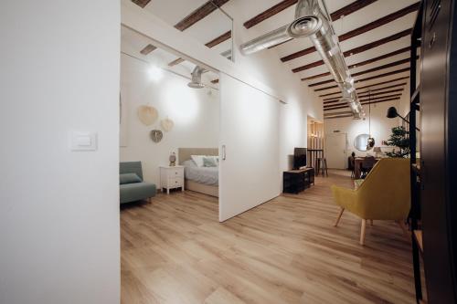 Apartamento Mercadal في توذيلا: غرفة معيشة وغرفة طعام بجدران بيضاء وأرضيات خشبية
