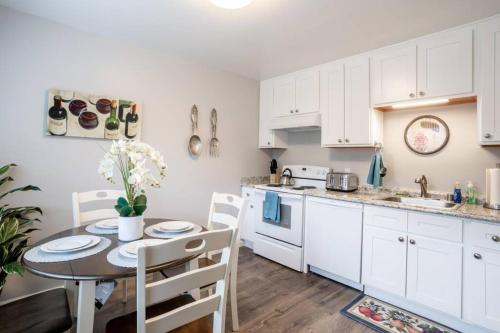 a kitchen with white cabinets and a table and chairs at Luxury stay near Oakridge Mall for vacation/work in San Jose