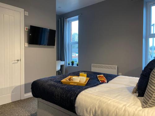 a hotel room with a tray of food on a bed at The North Wales Gathering - 9 Bedroom - EV Charging in Flint