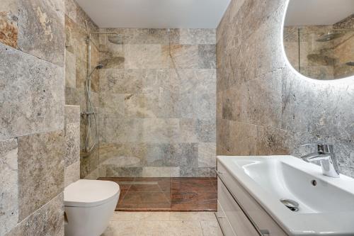 W łazience znajduje się umywalka, toaleta i lustro. w obiekcie Avanport Studio Gdynia w mieście Gdynia