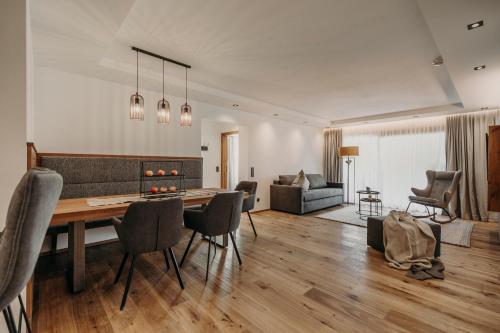 a living room with a wooden table and chairs at PoSt Boutique Apartments in Maria Alm am Steinernen Meer