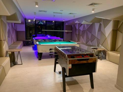 a pool table in a room with purple lighting at Skałka Zieleniec in Duszniki Zdrój