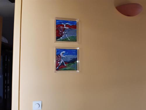 three pieces of art hanging on a wall at Red Art Maisonette in Kardhakáta