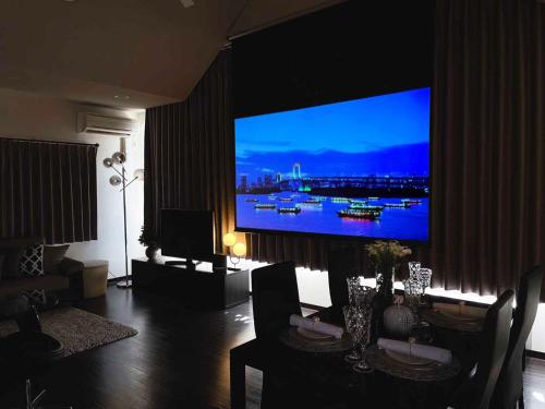 sala de estar con TV de pantalla plana grande en la pared en OUCHI HOTEL SUITE Temma en Hiroshima