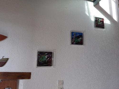 a wall with four pictures on a wall at Red Art Maisonette in Kardhakáta