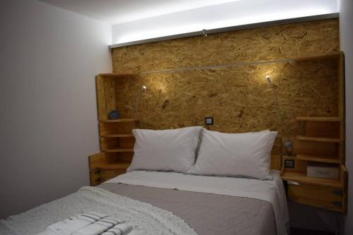a bedroom with a bed with a wooden headboard at h2h Anthi Comfort apt near Athens in Athens