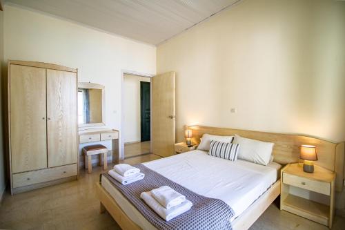 a bedroom with a large bed with two towels on it at SunRose Beach Aparthotel in Acharavi