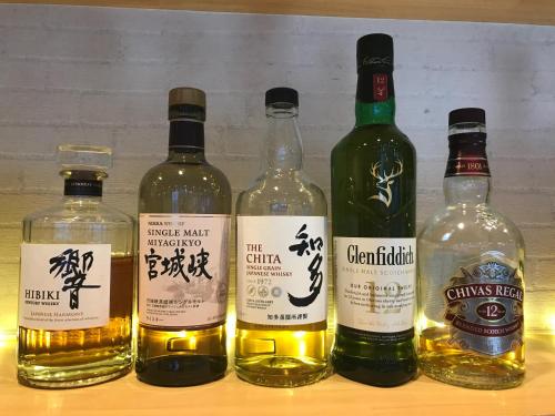 a group of four bottles of whisky on a shelf at The Address Akakura in Myoko