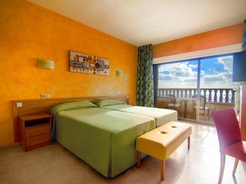 a bedroom with a large bed and a balcony at Hotel Servigroup La Zenia in Playas de Orihuela