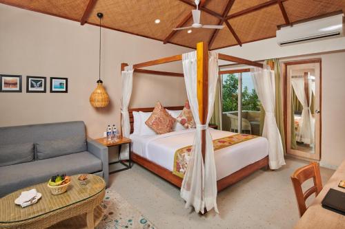 ein Schlafzimmer mit einem Bett und einem Sofa in der Unterkunft Swosti Chilika Resort in Kānāipur