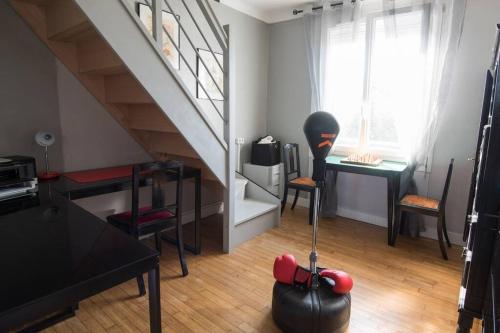 een woonkamer met een trap en een tafel en stoelen bij Entre parc et Haras in Hennebont