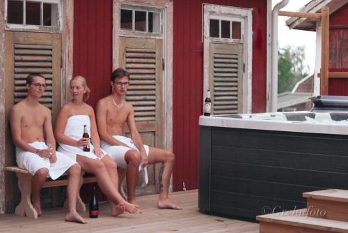 a group of people sitting on a bench next to a tub at Lundsbrunn B&B in Lundsbrunn
