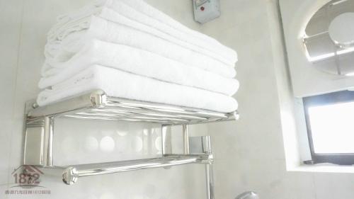 uma pilha de toalhas num toalheiro na casa de banho em Kowloon Mongkok 1812 Guest House em Hong Kong
