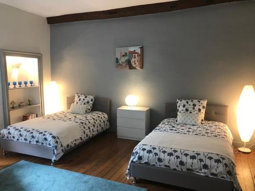 une chambre avec deux lits et un miroir dans l'établissement EGLANTINE APPARTEMENT CENTRE HISTORIQUE DE DINAN, à Dinan