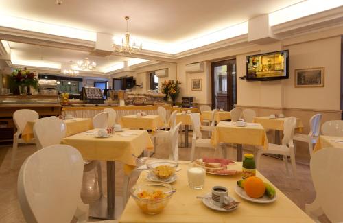restauracja z białymi stołami i białymi krzesłami w obiekcie Hotel Galileo w Rzymie