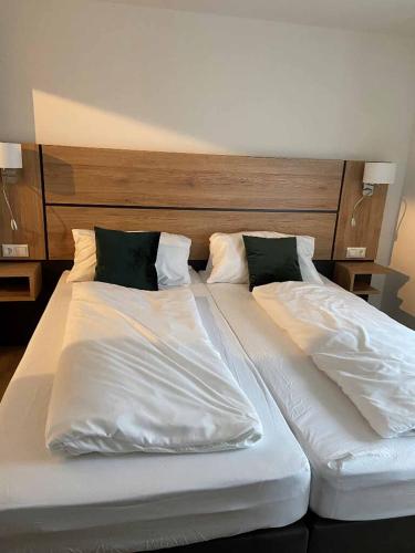 a large bed with white sheets and pillows at Ramspauer Hof in Regenstauf