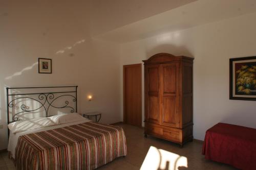 um quarto com uma cama e um armário de madeira em Masseria Casacapanna em Chieuti