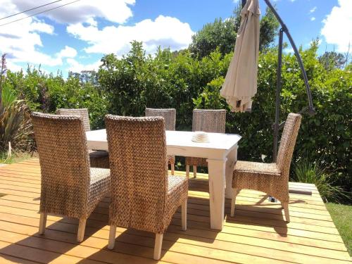 a table and chairs on a deck with an umbrella at Mangawhai Room in Mangawhai