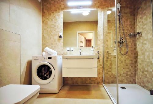 eine Waschmaschine und einen Trockner im Bad mit Dusche in der Unterkunft Nadmorskie Tarasy 503 in Kołobrzeg