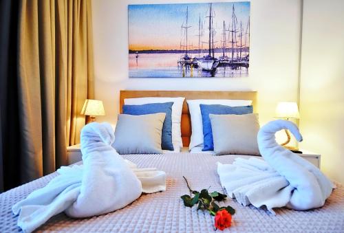 a bedroom with a bed with swans made out of towels at Nadmorskie Tarasy 503 in Kołobrzeg