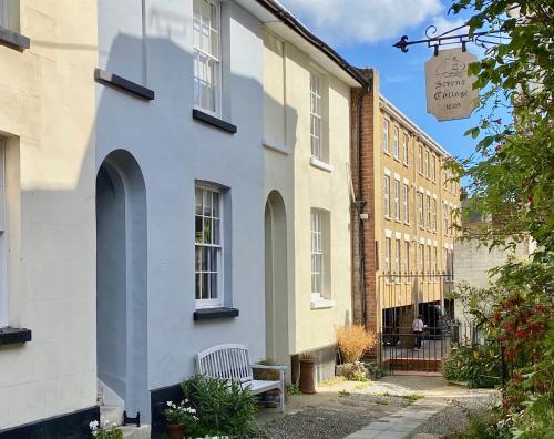 a white building with a bench in front of it at Picturesque Seaside Cottage Next to Viking Bay - Broadstairs in Broadstairs