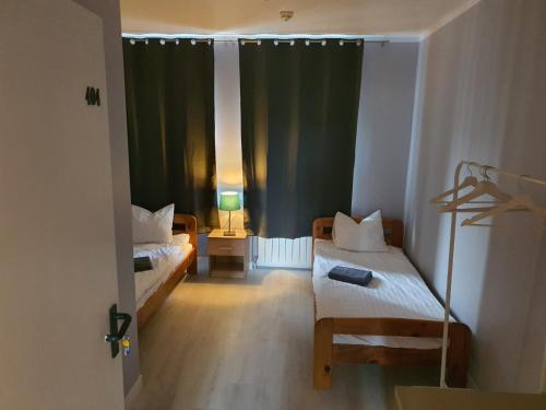 ワルシャワにあるJasna Hotelikのベッド2台と窓が備わる小さな客室です。