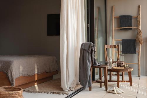 a bedroom with a bed and a chair and a table at OKU Ibiza in San Antonio