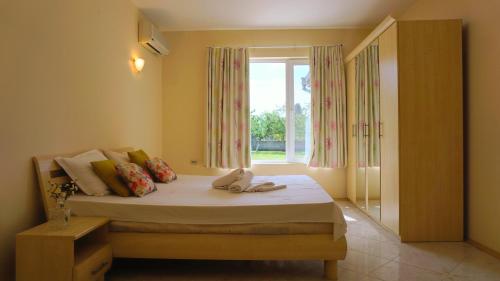 a bedroom with a bed with a window at Вила Релакс - Villa Relax in Sokolovo