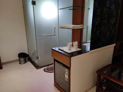 ein Bad mit einer Dusche und einer Theke mit einem Waschbecken in der Unterkunft Hotel Vintage in Vadodara
