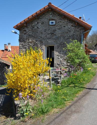 a stone house with flowers in front of it at Gîte de la Meille in Chamalières-sur-Loire