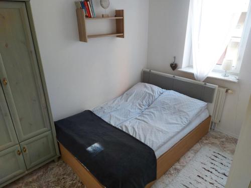 a small bed in a room with a window at Apartament Portowy z garażem, ul Towarowa in Kołobrzeg