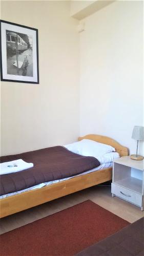 a bedroom with a bed and a picture on the wall at Hostel na Żurawiej in Warsaw