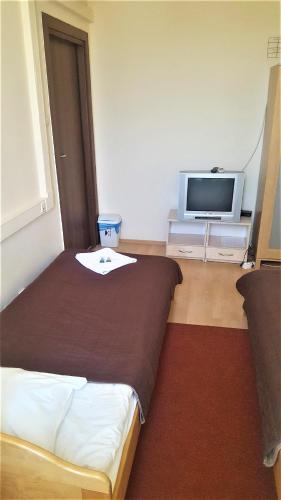 a hotel room with a bed and a tv at Hostel na Żurawiej in Warsaw