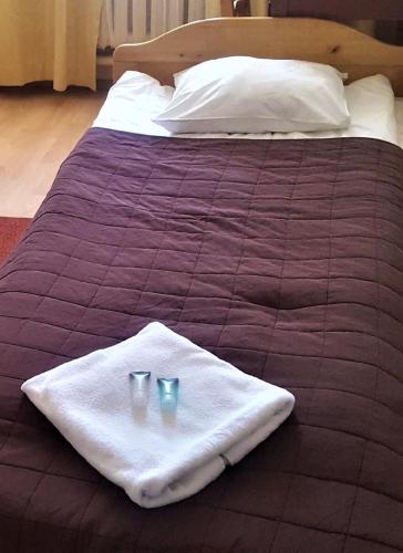 a bed with two glasses on a towel on it at Hostel na Żurawiej in Warsaw