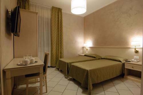 une chambre d'hôtel avec un lit et une table dans l'établissement Albergo CAVALLINO 10, à Toscolano Maderno