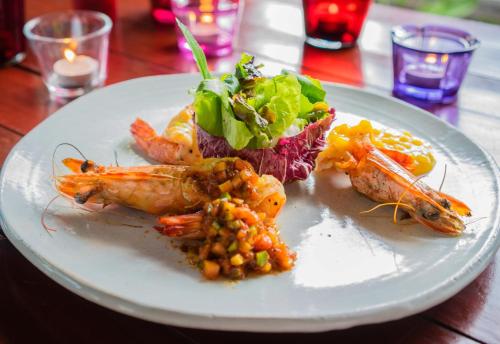 a plate of food with shrimp and vegetables on a table at Let's Sea Hua Hin Al Fresco Resort in Hua Hin