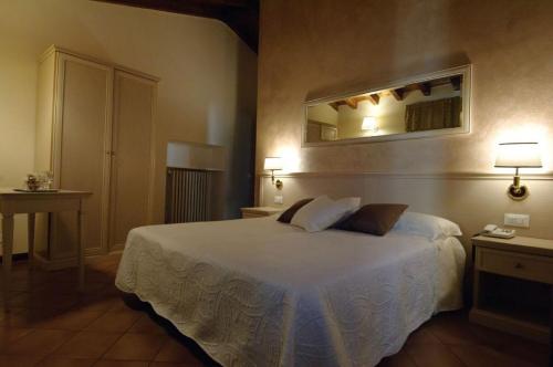 a bedroom with a bed and a mirror on the wall at Albergo CAVALLINO 10 in Toscolano Maderno