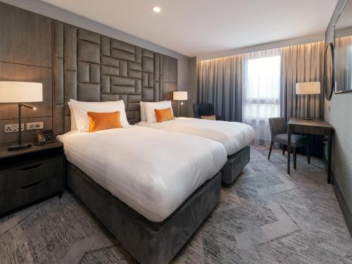 a hotel room with a large bed and a desk at voco Edinburgh - Haymarket by IHG in Edinburgh