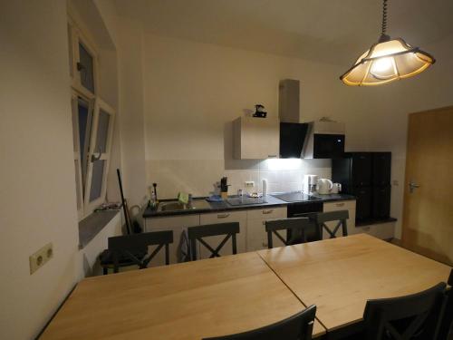 a kitchen with a wooden table and chairs in it at Touristisches Begegnungzentrum Melchow in Melchow
