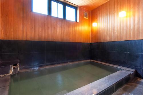 a pool of water in a room with a window at Oyado Yukizumi in Kusatsu
