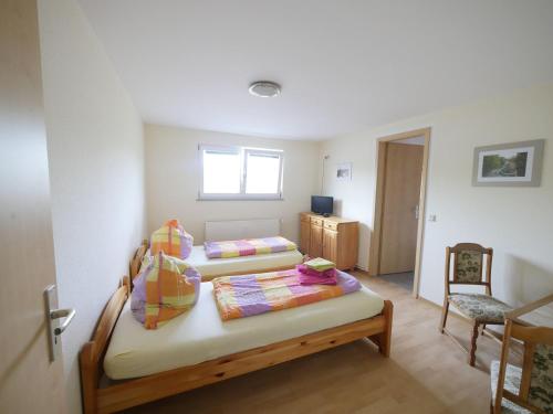 a room with two beds and a chair in it at Touristisches Begegnungzentrum Melchow in Melchow