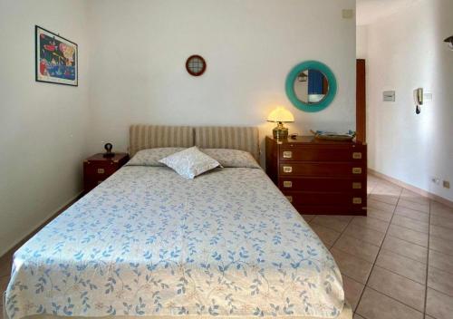 a bedroom with a bed and a dresser and a mirror at Lilli's House in Porto Santo Stefano