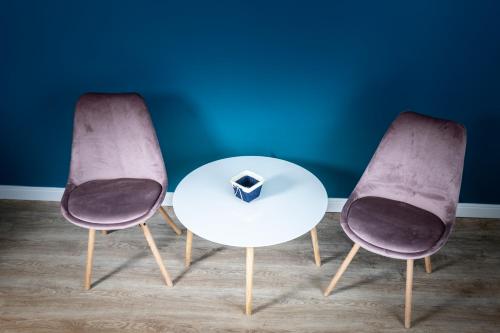 two chairs and a table with a box on it at English House in Bistriţa