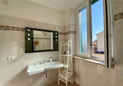 a bathroom with a sink and a mirror and a window at Lilli's House in Porto Santo Stefano