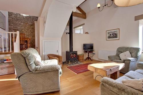 a living room with two couches and a fireplace at Nethergill Farm in Skipton